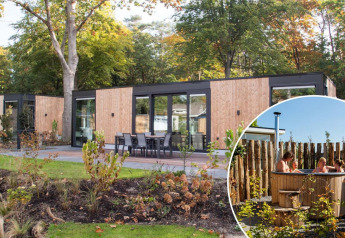 Moderne Veluwehoeve Wellness lodge med hottub ved Bospark Ede i Holland, omgivet af grøn natur.