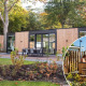 Moderne Veluwehoeve Wellness lodge med hottub ved Bospark Ede i Holland, omgivet af grøn natur.