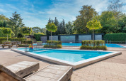 Piscina all'aperto con sdraio e vegetazione presso Bungalowpark Het Verscholen Dorp, Gelderland, Paesi Bassi.