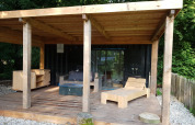 Terraza de madera en una tiny house de contenedor marítimo con muebles, Buytenplaets Suydersee, Países Bajos.