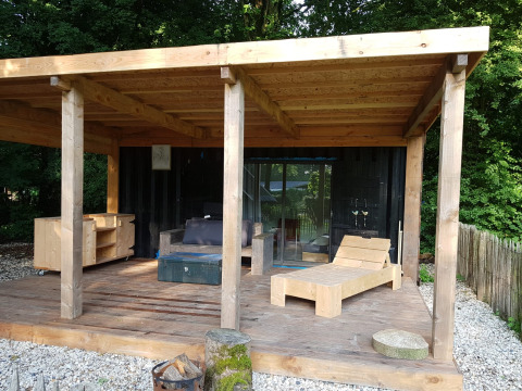 Terraza de madera en una tiny house de contenedor marítimo con muebles, Buytenplaets Suydersee, Países Bajos.