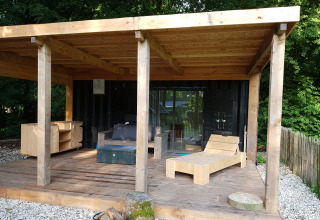 Terraza de madera en una tiny house de contenedor marítimo con muebles, Buytenplaets Suydersee, Países Bajos.