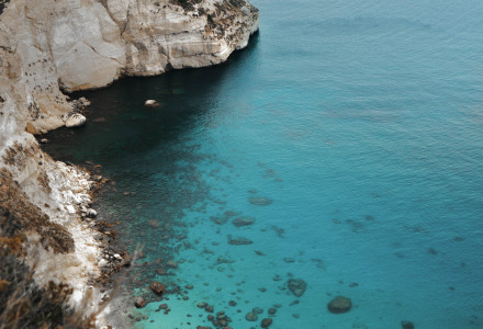 Acantilados y agua turquesa cerca de Cannigione, Cerdeña, Italia, vistos desde una perspectiva alta.