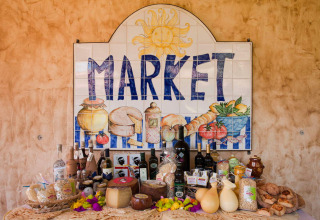 Marktbord met Sardijnse kaas, wijn en andere streekproducten bij Centro Vacanze Isuledda in Sardinië.