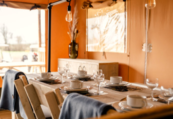 Stilvoll gedeckter Esstisch für sechs Personen in der Glamping Lodge bei Camping Waddenzee, Niederlande.