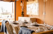 Tavolo da pranzo apparecchiato per sei nella Glamping Lodge al Camping Waddenzee, Paesi Bassi, ambiente accogliente.