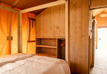 Innenaufnahme einer Glamping Lodge bei Camping Waddenzee in den Niederlanden mit Holzwänden.