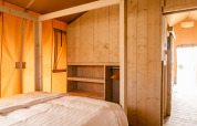 Indvendigt billede af et Glamping Lodge værelse på Camping Waddenzee i Holland med træpaneler.