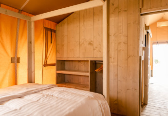 Indvendigt billede af et Glamping Lodge værelse på Camping Waddenzee i Holland med træpaneler.
