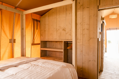 Foto interna di una Glamping Lodge al Camping Waddenzee nei Paesi Bassi, con pareti in legno chiaro.