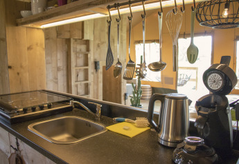 Cuisine moderne à la Glamping Lodge, Camping Waddenzee, Pays-Bas, avec ustensiles et appareils ménagers.