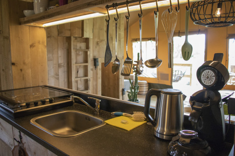 Cocina moderna en Glamping Lodge, Camping Waddenzee, Países Bajos, con utensilios y electrodomésticos.
