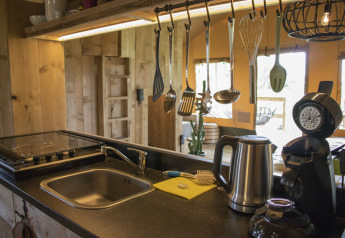 Moderne køkkeninteriør på Glamping Lodge, Camping Waddenzee i Holland, med redskaber og elektriske apparater.