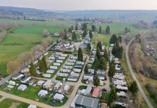 Vista aérea del parque vacacional Camping Oos Heem en Lieja, Bélgica, rodeado de campos verdes y árboles.