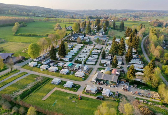 Luchtbeeld van Camping Oos Heem, een vakantiepark met caravans en veel groen in Luik, België.