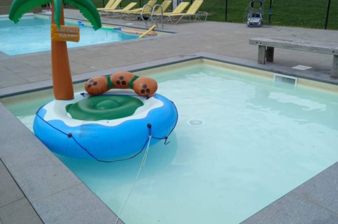 Kinderbecken mit einer aufblasbaren Insel und Palme auf dem Campingplatz Oos Heem in Lüttich, Belgien.