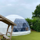 Cúpula geodésica en Costa Kabrita, Países Bajos, con mesa de picnic de madera en entorno verde.