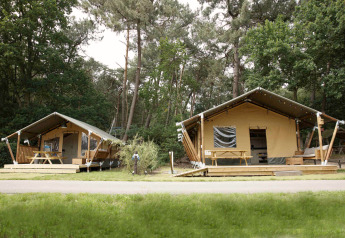 Twee safaritent-lodges in het bos met houten terrassen en picknicktafels, Safari tent lodge.