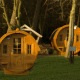 To runde tiny houses kaldet Wijnvat står blandt træerne ved Costa Kabrita i Holland ved solnedgang.