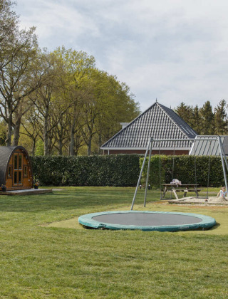 Parque vacacional Costa Kabrita en North-Brabant con área de juegos, trampolín, cabañas y alpacas.