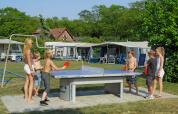 Des enfants et adultes jouent au tennis de table dehors au parc de vacances Costa Kabrita, Brabant septentrional, Pays-Bas.