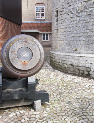 Antiguo cañón junto a una pared de piedra en Huijbergen, Brabante Septentrional, Países Bajos