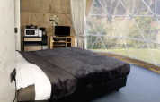 Interieur van Dome bij Costa Kabrita in Nederland met bed, panoramavenster en moderne voorzieningen.