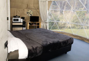 Innenaufnahme der Dome-Lodge bei Costa Kabrita in den Niederlanden mit Bett, Ausblick und Annehmlichkeiten.