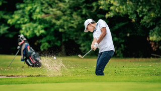 Golfer schlägt Ball aus dem Sandbunker im Camping Castel L'Orangerie de Lanniron, Bretagne, Frankreich.