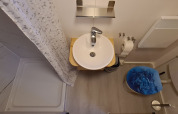 Kleines Badezimmer im Tiny House im Vakantiepark 't Urkerbos mit Dusche, Waschbecken und Toilette.