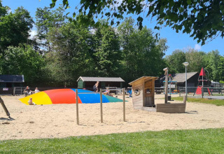 Speelplein met kleurrijk springkussen en speeltoestellen bij Vakantiepark 't Urkerbos, Flevoland.