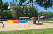 Speeltuin met gekleurde springkussen en speeltoestellen in Vakantiepark 't Urkerbos, Flevoland.
