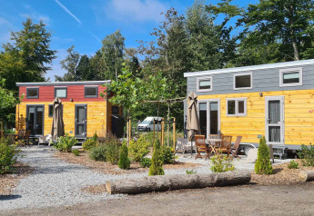 Tiny Houses at Vakantiepark 't Urkerbos in the Netherlands, surrounded by greenery and outdoor seating.