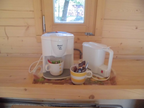 Cafetera y hervidor eléctrico sobre encimera de madera en cabaña de Vakantiepark 't Urkerbos, Flevoland, Países Bajos.