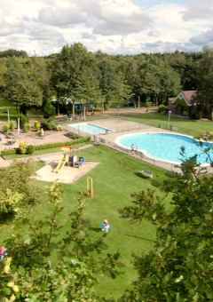A holiday park with pool, playground, lawns and buildings at Vakantiepark 't Urkerbos in Flevoland, Netherlands.