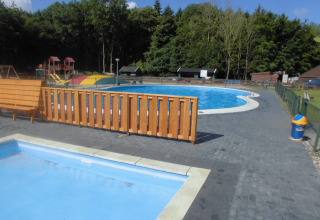Außenpool und Spielplatz im Vakantiepark 't Urkerbos, Ferienpark in Flevoland, Niederlande, bei Sonnenschein.