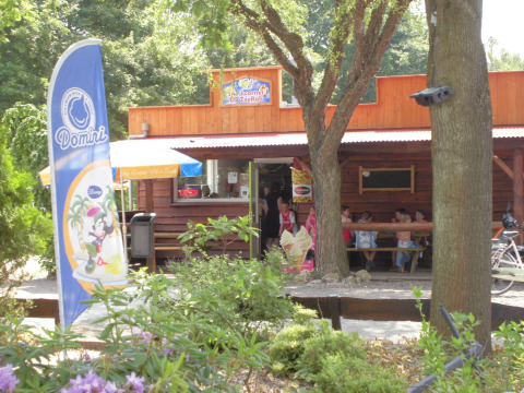 Heladería en Vakantiepark 't Urkerbos, Flevoland, Países Bajos, con clientes y árboles alrededor.