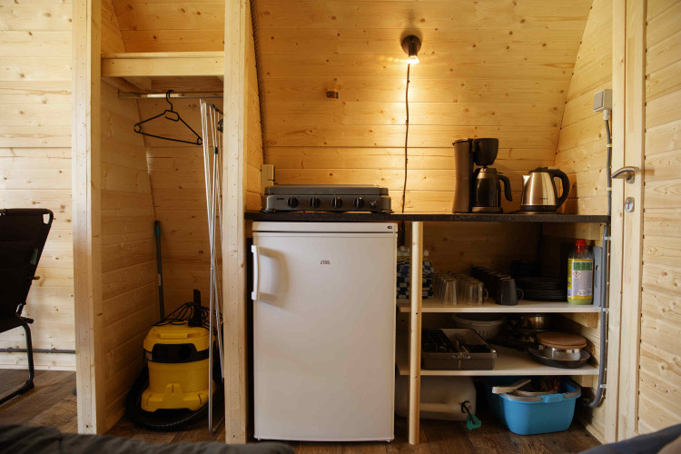 Küchenzeile in einer Glamping Pod bei Costa Kabrita in den Niederlanden mit Kühlschrank und Geräten.