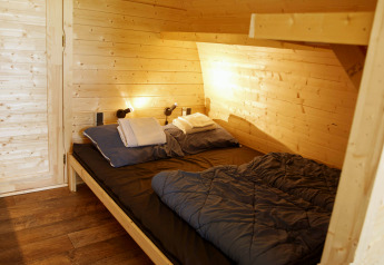 Gezellige houten Glamping Pod slaapkamer met dubbel bed bij Costa Kabrita lodge in Nederland.