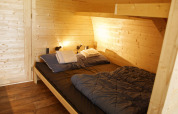 Cozy wooden Glamping Pod bedroom with double bed, Costa Kabrita lodge in the Netherlands, neatly made up.