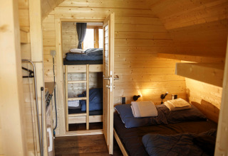 Pod de glamping en bois avec lit double et lits superposés au Costa Kabrita, Pays-Bas.
