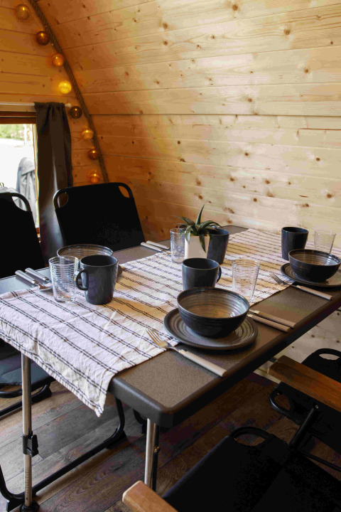 Mesa acogedora para cuatro en un Glamping Pod de madera en Costa Kabrita, Países Bajos, lista para comer.
