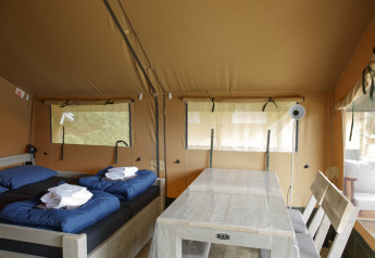 Indvendig udsigt over en safari-teltlodge med to senge og et spisebord på Costa Kabrita, Holland.