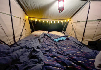 Sfeervolle tent met bed, lichtjes en lantaarn in de boomhut Treelodge bij Costa Kabrita, Nederland.