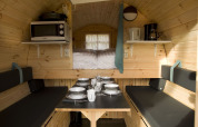 Et hyggeligt interiør af et tiny house på Costa Kabrita, Wijnvat, med spisebord og køkkenudstyr.