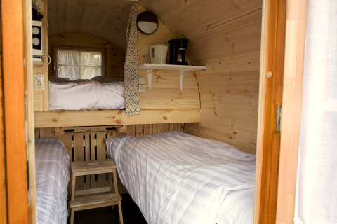 Intérieur de la tiny house Wijnvat à Costa Kabrita, Pays-Bas, avec lits superposés et cafetière.
