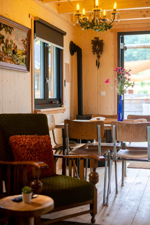 Accogliente soggiorno della tiny house Jachthut al Camping Vinkenhof, Paesi Bassi, con arredi rustici.