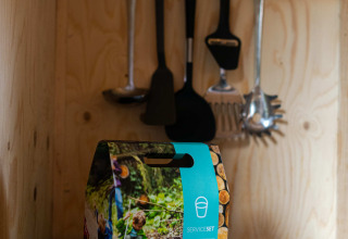 Cocina pequeña con utensilios y set de servicio en la tiny house Jachthut en Camping Vinkenhof.