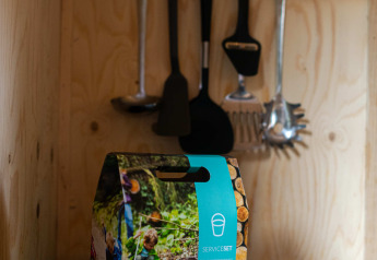 Small kitchen setup with utensils and service kit box in the Jachthut tiny house at Camping Vinkenhof.
