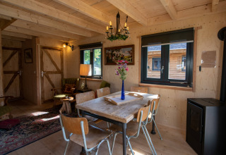 Soggiorno accogliente nella tiny house Jachthut al Camping Vinkenhof in Olanda, con arredi in legno.